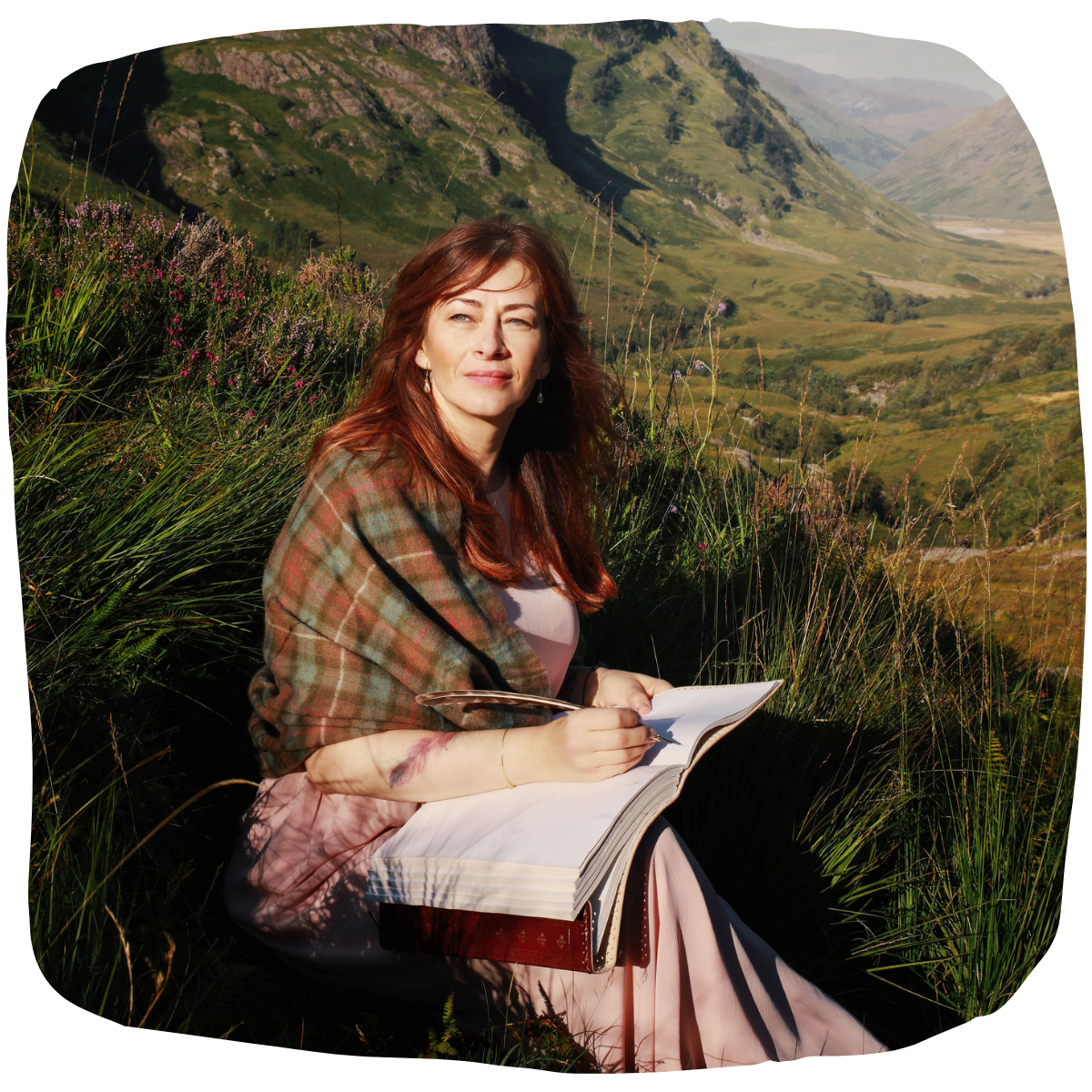 Beatrice Bradshaw sitting in the Scottish Highlands, writing a book