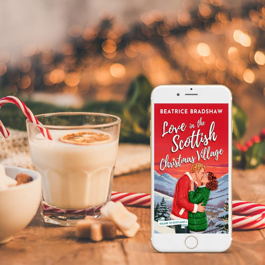 Phone displaying the book cover of Love in the Scottish Christmas Village with a glass of eggnog and candy canes on a festive background